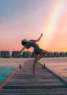 woman standing on dock by Drew Colins courtesy of Unsplash.