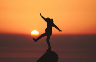 photo of silhouette photo of man standing on rock by Aziz Acharki courtesy of Unsplash.