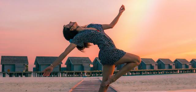 woman standing on dock by Drew Colins courtesy of Unsplash.